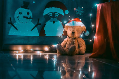 Teddy bear with illuminated string lights during christmas