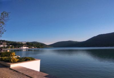 Scenic view of lake against clear blue sky