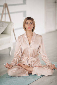 Portrait of young woman sitting on floor