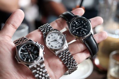 Close-up of human hand holding wristwatches