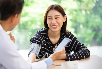 Doctor checking blood pressure of patient in clinic