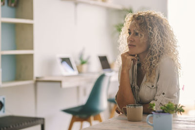 Portrait of young woman using mobile phone at home