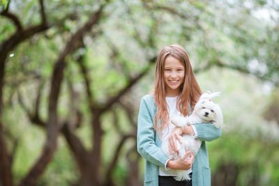 Portrait of a smiling young woman holding tree