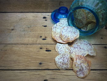 High angle view of chips by blue jar on wooden table