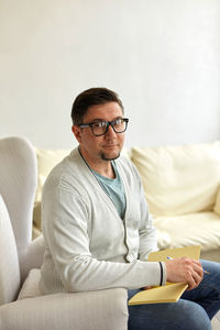 Young man sitting on sofa at home