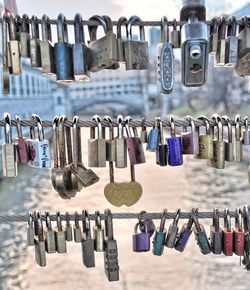 Close-up of padlocks hanging on metal against sky