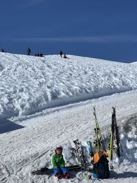 People on snow covered mountain against sky