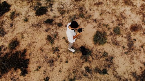 High angle view of man holding remote control standing on land