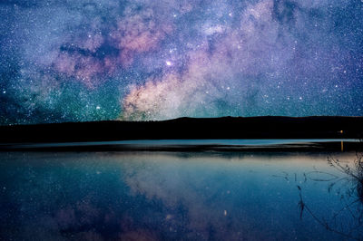 Scenic view of lake against sky at night