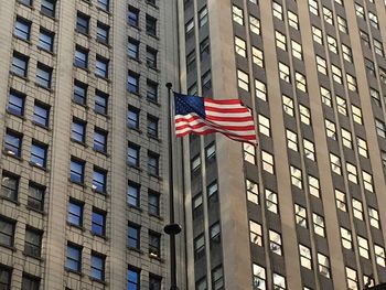 Low angle view of american flag 8against buildings