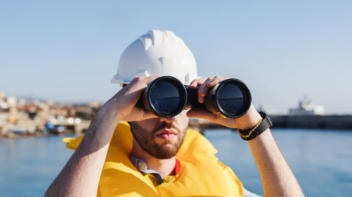 Sailor watching with binoculars close up