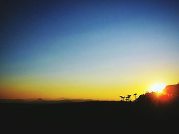 Scenic view of silhouette landscape against clear sky during sunset