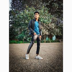 Portrait of young man standing against plants
