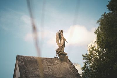 Low angle view of statue against cloudy sky