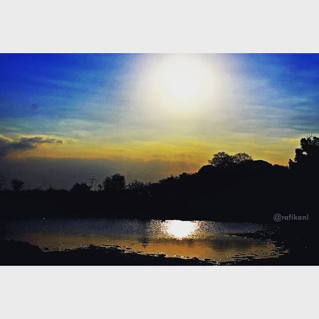 transfer print, water, sunset, tranquil scene, scenics, reflection, tranquility, sun, beauty in nature, sky, auto post production filter, silhouette, lake, tree, nature, sunlight, idyllic, sunbeam, outdoors, cloud - sky