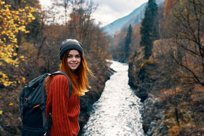 Smiling young woman in forest during autumn