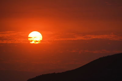 Scenic view of silhouette mountain against romantic sky at sunset