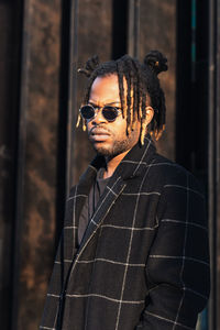 Portrait of young man wearing sunglasses standing outdoors