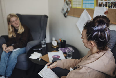 Mental health professional discussing with female student in school office