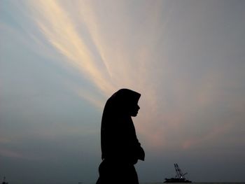 Silhouette man against orange sky during sunset