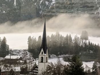 Traditional building by trees during winter