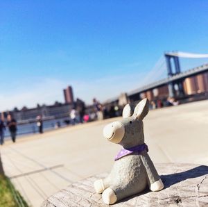 Close-up of toy on bridge against clear blue sky