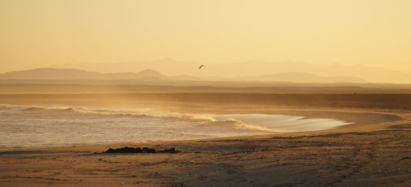 Scenic view of beach against sky during sunset