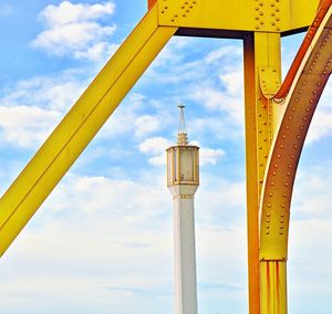 Low angle view of metallic structure against cloudy sky