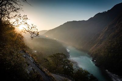 Scenic view of river amidst mountains against sky