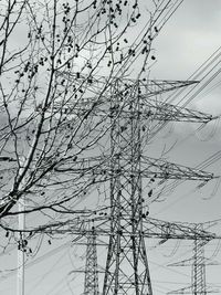 Low angle view of electricity pylon against sky