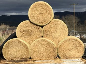 Hay bales on field against sky