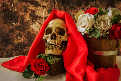 Close-up of human skull by roses on table