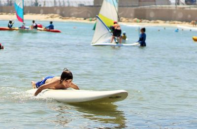 Cute boy on paddleboard in sea