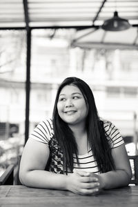 Portrait of smiling young woman sitting outdoors