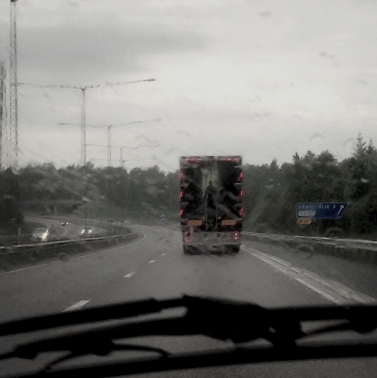 transportation, road, car, mode of transport, land vehicle, road marking, windshield, sky, glass - material, transparent, street, vehicle interior, car interior, on the move, the way forward, travel, cloud - sky, tree, window, no people