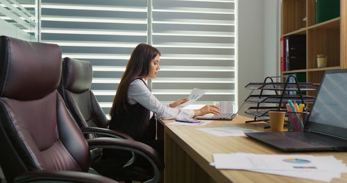 Employee making changes in documents on laptop in calm atmoshere. 