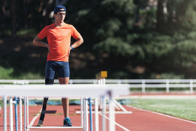 Man with artificial leg standing on running track