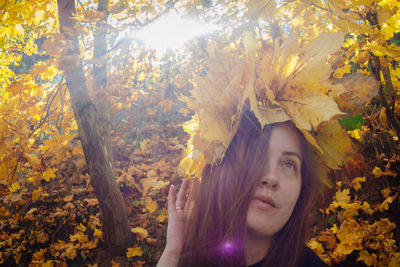 Portrait of young woman with autumn leaves