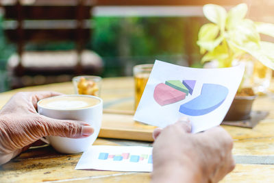 Cropped image of woman holding graph at table