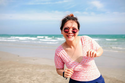 Young asian woman in a cute dress is relaxing at the beach.