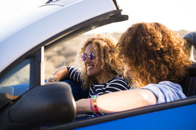 Cheerful women sitting in car