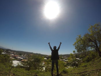 Rear view of man standing on landscape against sky