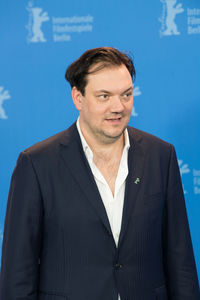 Close-up of a man standing against blue sky