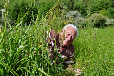 Portrait of man holding grass in field