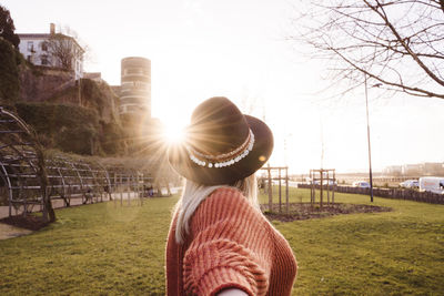 Rear view of woman in park against sky