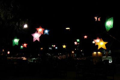 Low angle view of illuminated street lights in city at night