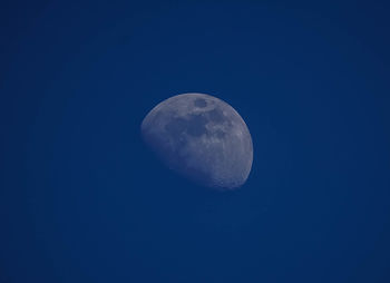 Low angle view of moon against clear blue sky