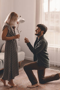 Side view of couple standing against wall