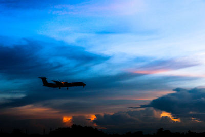 Low angle view of silhouette helicopter against sky during sunset