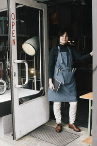 Portrait of female shop owner standing at entrance